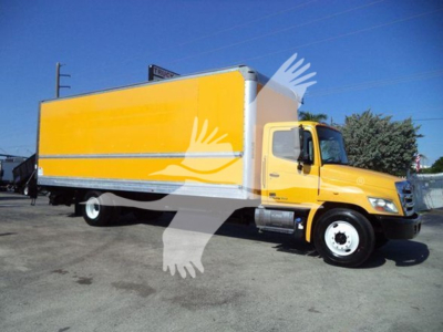 Truck side view of a yellow 2019 Hino 268A box truck with a large cargo box.