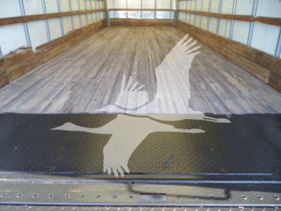 Truck cargo area of a 2019 Hino 268A with wooden floor and ramp, showing a bird graphic on a black textured surface.