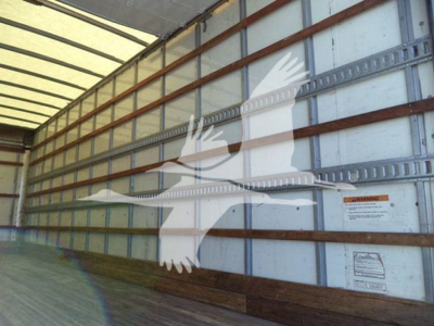 Truck trailer interior with side wall text and warning labels visible; no detailed model text legible.