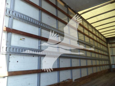 Truck trailer interior showing sidewall with horizontal rails and wooden battens