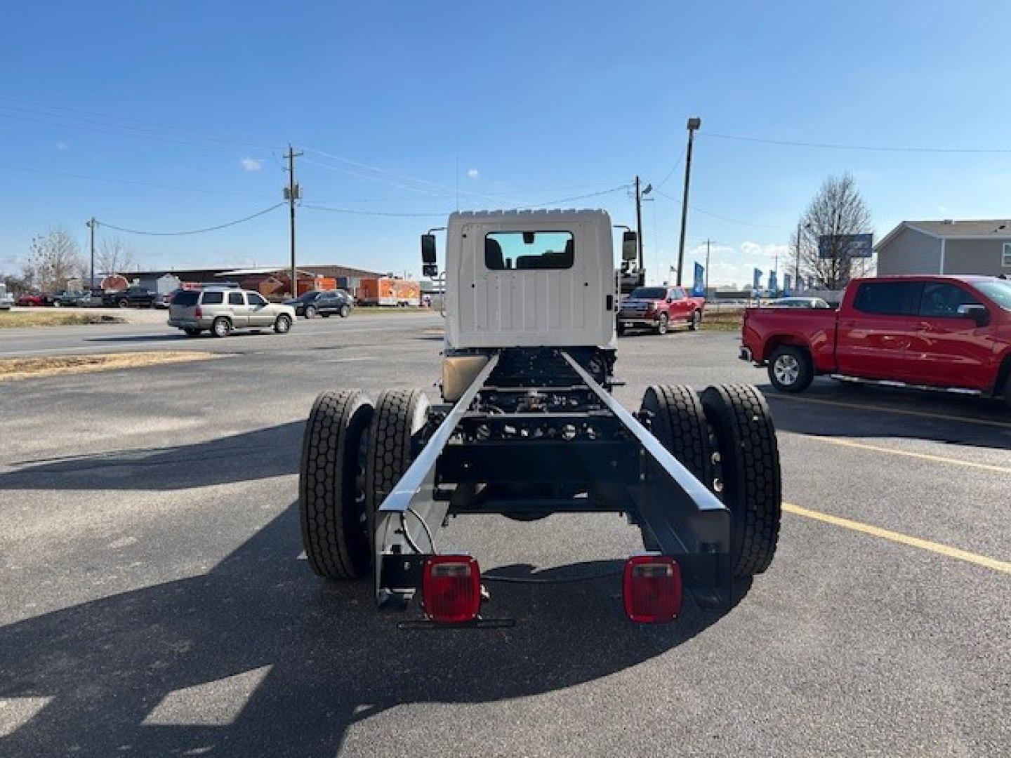 Rear view of a 2025 Hino L6 cab and chassis frame showing dual rear axles, chassis rails, and taillights.