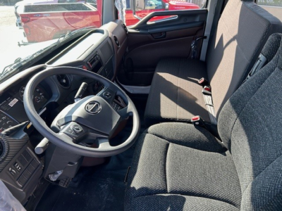 Cab interior of a 2025 Hino L6 truck showing steering wheel, dashboard, and front seats.