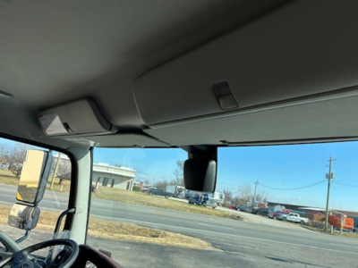 Cab interior of a 2025 Hino L6 truck showing the sun visor and overhead console.