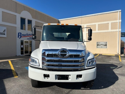 Hino L6 cab and chassis front view showing bold chrome grille and Hino emblem.