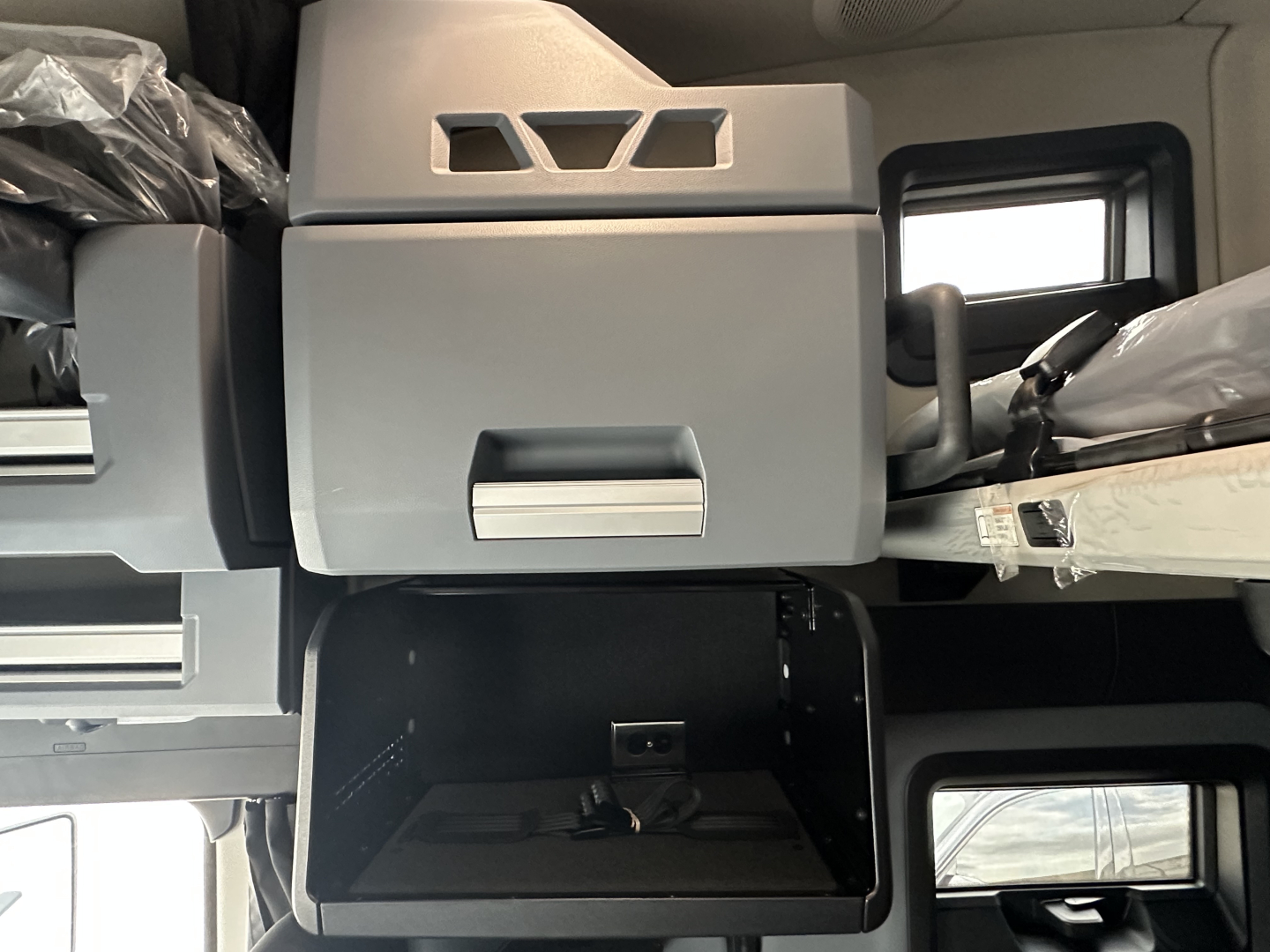 Vehicle cab interior showing storage compartments and dashboard area of a Mack PR64T76H truck cab.