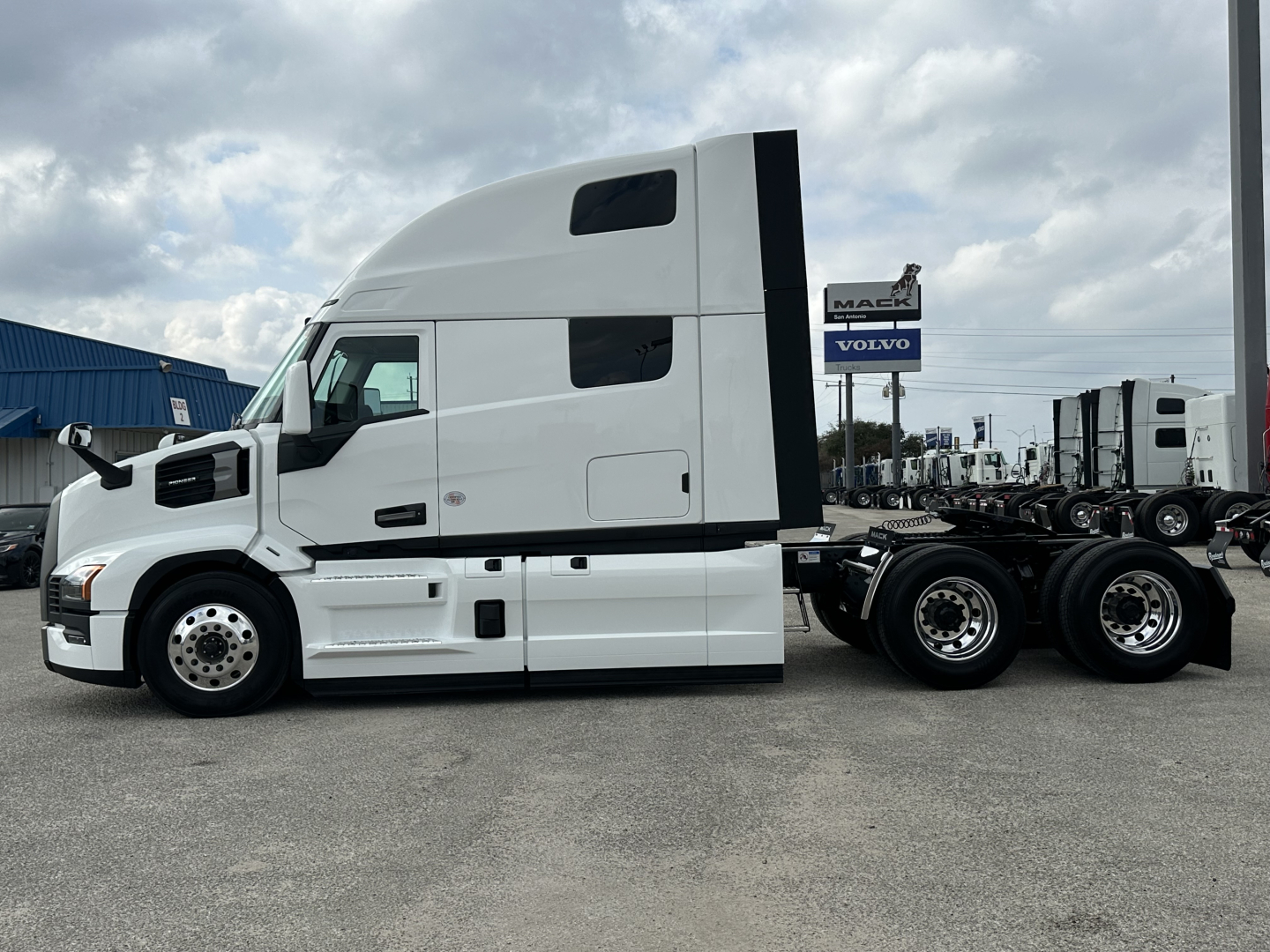 Truck: Mack PR64T76H conventional sleeper side view showing cab with aerodynamic fairings and dual rear axles.