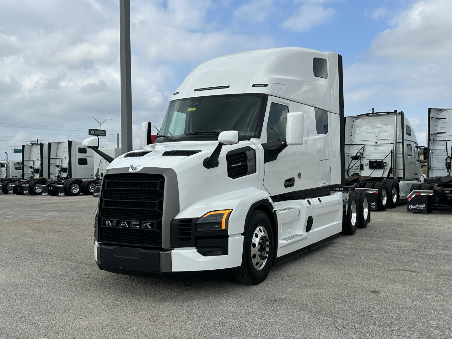 Mack PR64T76H conventional sleeper truck in a parking lot showing front and side profile.