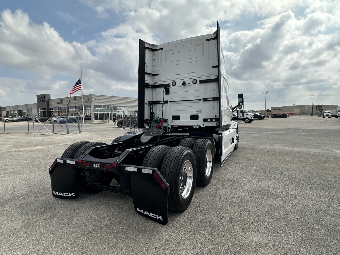 Mack PR64T76H tractor rear view showing dual rear axles, fifth wheel, and mud flaps with Mack logo.