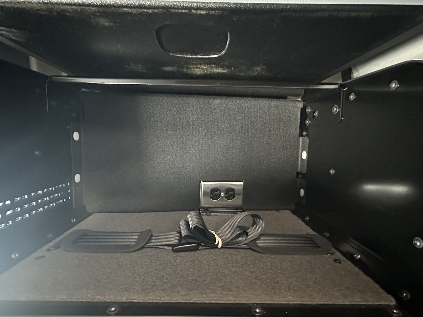 Truck cab storage compartment with power outlet and corded plug visible in a Mack PR74TPR truck image.