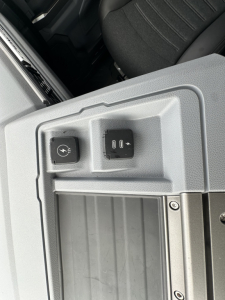 Cab interior window switch area with two knobs visible on a Mack PR64T76H truck cab door panel.