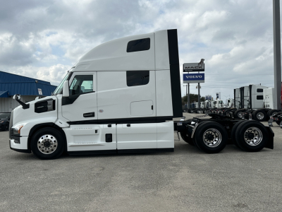 Truck: Mack PR64T76H conventional sleeper side view showing cab with aerodynamic fairings and dual rear axles.