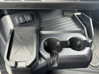 Truck interior showing console with cup holders and storage trays in a Mack PR64T76H cab.