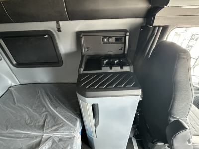 Mack PR64T76H interior sleeper cab showing center console with cup holders and USB ports.