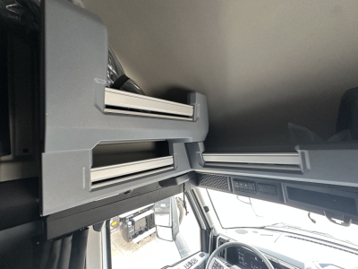 CAB interior overhead storage compartments of a new 2026 Mack PR64T76H truck showing multiple stacked drawers and control panels.