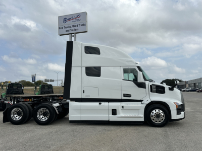 Truck side view of a white 2026 Mack PR64T76H conventional sleeper tractor showing long hood, sleeper cab, and rear wheels.
