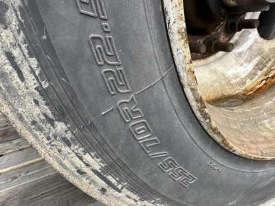 Trailer wheel and tire close-up showing 225/70R19.5? markings and rim edge