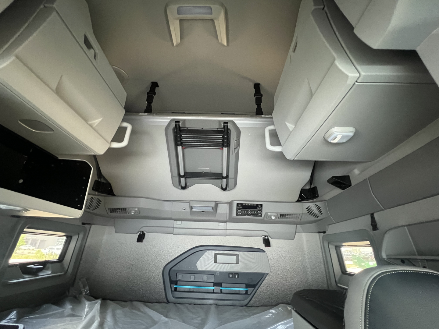 Volvo VNL64T860 sleeper cab interior with overhead storage, dash area, and control panels visible.