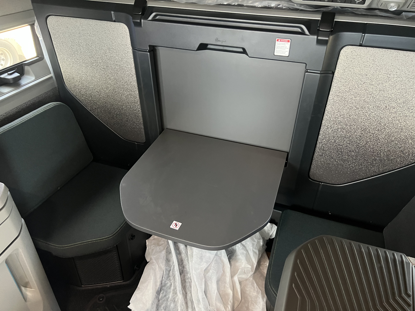 Volvo VNL64T860 sleeper cab interior showing fold-out table and seating area with storage panels.