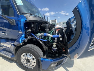Volvo VNL64T860 engine bay view showing exposed components with blue hoses and coolant system; open hood on drivers side.