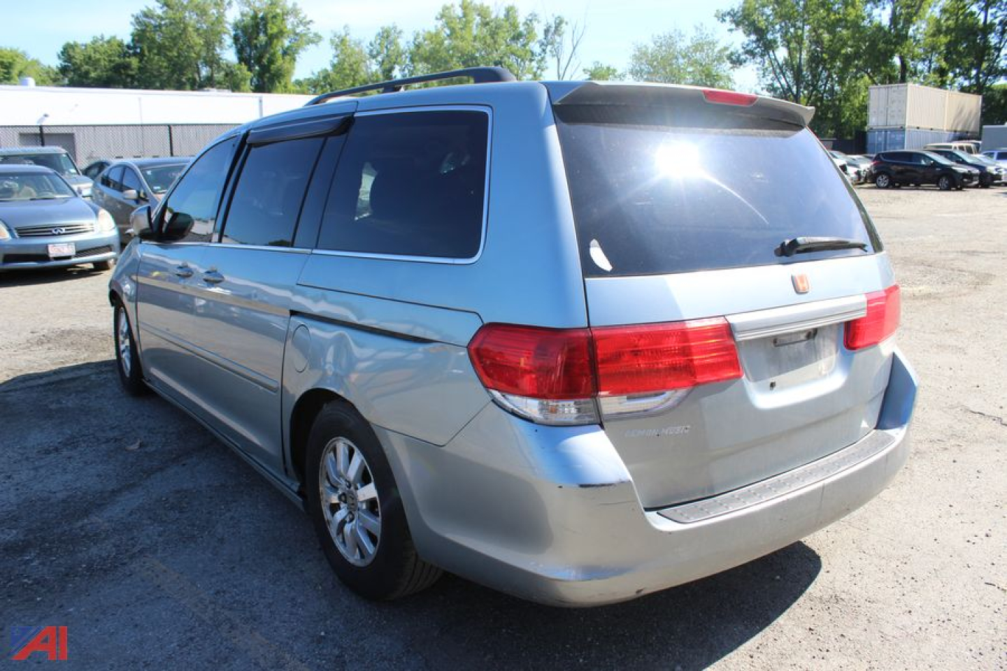 Minivan rear three-quarter view of a silver 2008 Honda Odyssey showing tail lights and rear window decals.