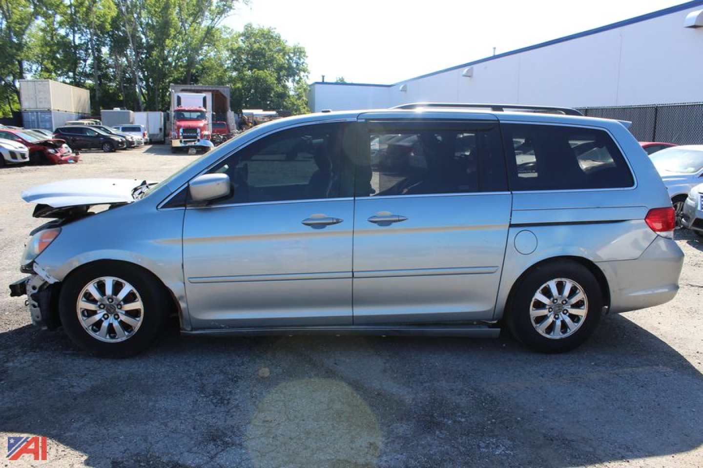 Honda Odyssey minivan side view showing front damage and side doors, silver exterior, blue-tinted windows.