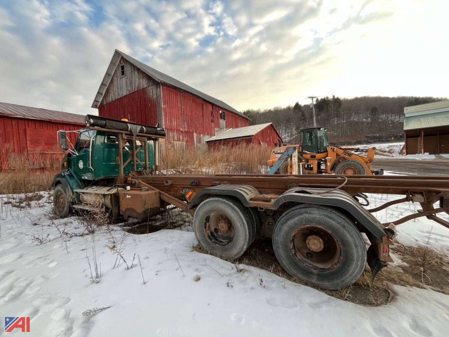 2005 Sterling LT9500 Roll Off Truck in a snowy yard with a red barn in the background and a loader nearby.