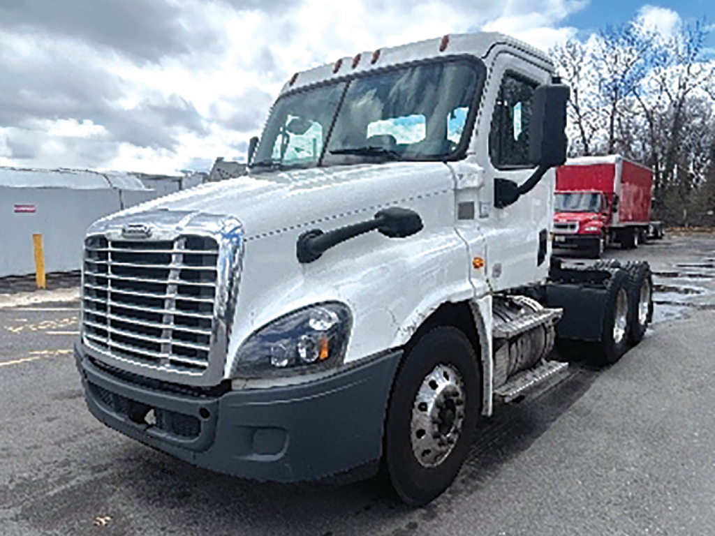 Truck cab showing Freightliner Cascadia125 chassis with front grille, white cab, and dual rear axles.
