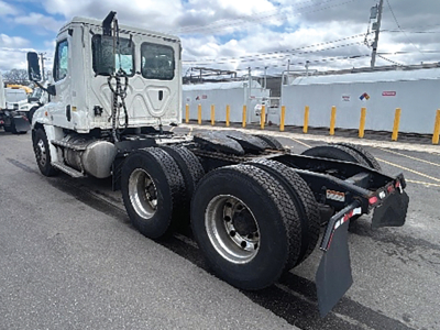 Freightliner Cascadia125 truck chassis with dual rear axles and lifted cab, show rear wheels and chassis.