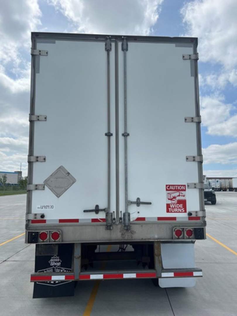 Rear view of a white utility van/trailer with double rear doors, safety decals, and taillights. VIN tag or placards not clearly legible; stock number U90970 noted.