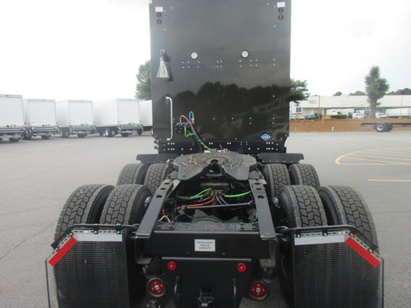 Freightliner Cascadia 126 chassis view showing dual rear-axle configuration and wiring harnesses; visible components include frame, drive shafts, and air lines.