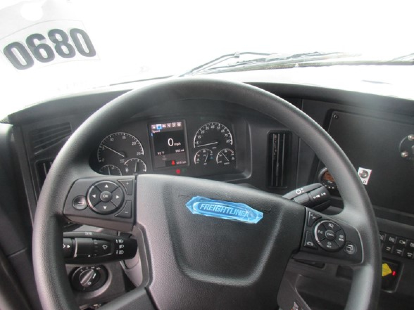 Dashboard view in a Freightliner Cascadia 126 with steering wheel and instrument cluster visible.