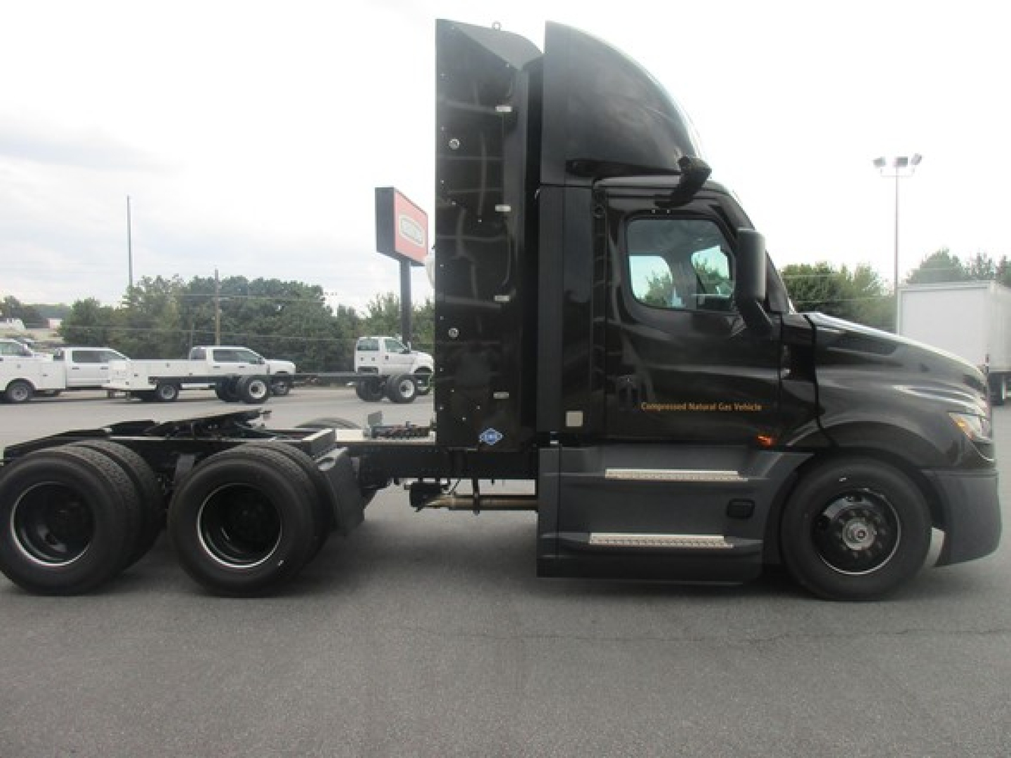 Freightliner Cascadia 126 day cab side profile showing tractor with black paint, upright sleeper, steering cab and rear wheels, no trailer attached.