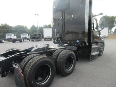 Truck chassis and cab of a 2026 Freightliner Cascadia 126 from rear quarter, showing triple rear axles and fifth wheel area