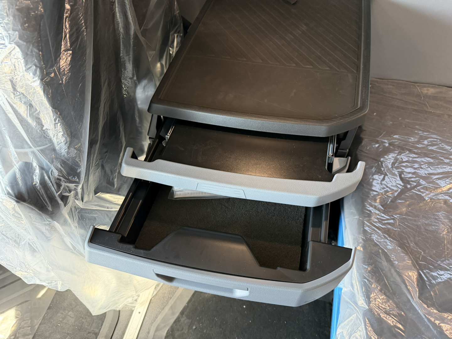 Step-by-step view inside a Mack PR64T76H truck cab showing two extended plastic storage drawers/steps in open position.