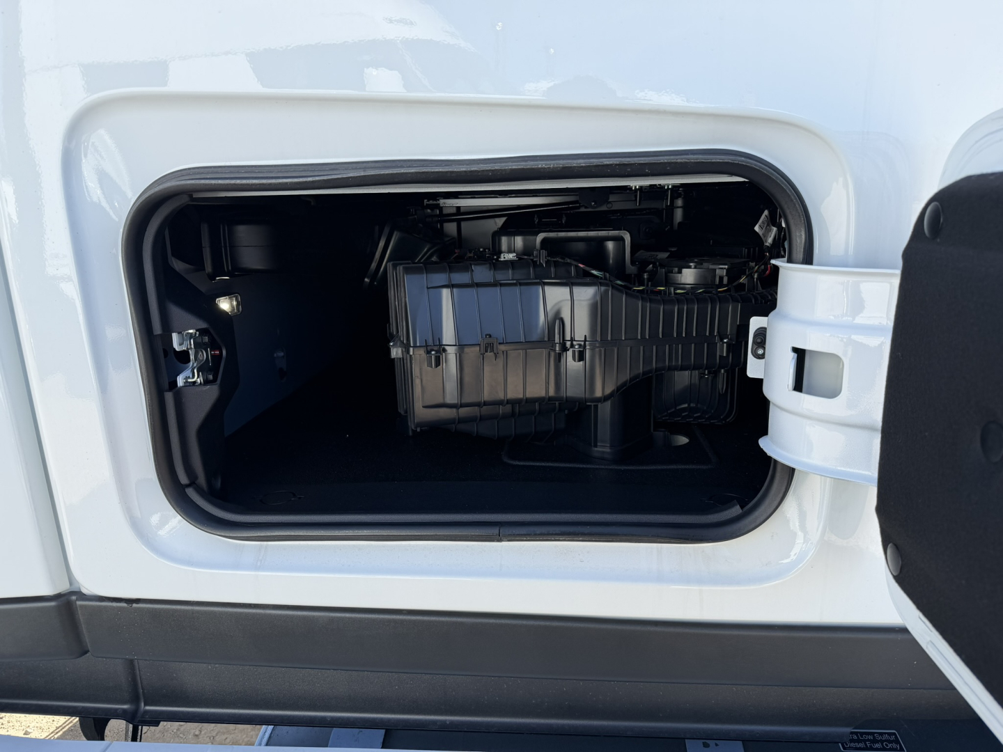 Mack PR64T76H truck engine bay view showing intake air filter housing and side access compartment.