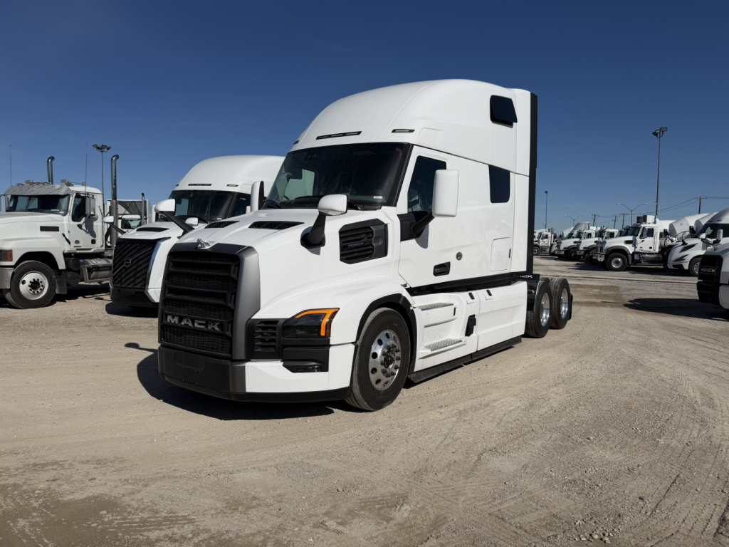 Mack PR64T76H conventional sleeper tractor in a dealer lot, white with black grille, showing front and side views