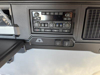 Truck cab dashboard controls and vents in view from interior, HVAC and media cluster visible.