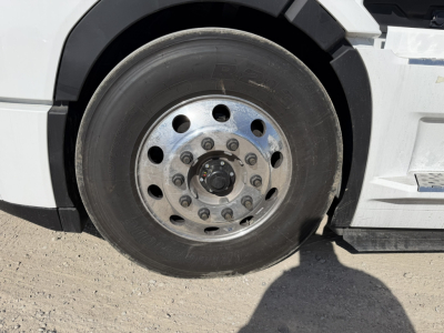 Wheel and tire close-up on Mack PR64T76H truck showing steel wheel with lug nuts and tire tread.
