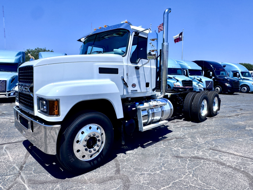 Mack PI64T conventional daycab showing front left view and chassis, with dual rear axles and fuel tanks.