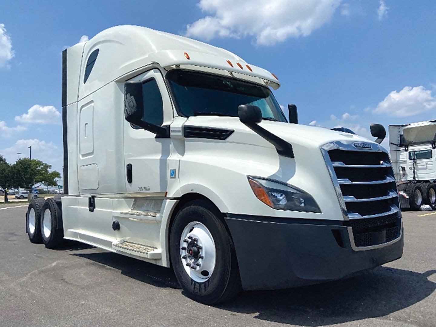 Truck cab showing 2020 Freightliner Cascadia 126 with white exterior, sleeper cab, front grille, dual rear axles, and chrome accents.
