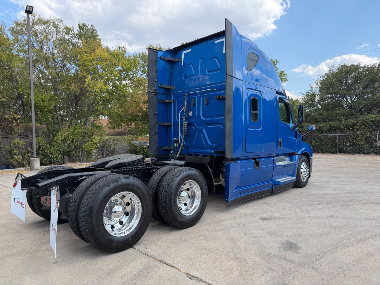 Freightliner PT126064ST tractor cab in blue, side view showing rear dual axles and fifth-wheel area.