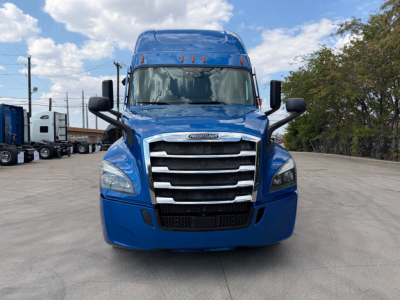 Front view of a blue Freightliner PT126064ST truck showing grille, headlights, and side mirrors.