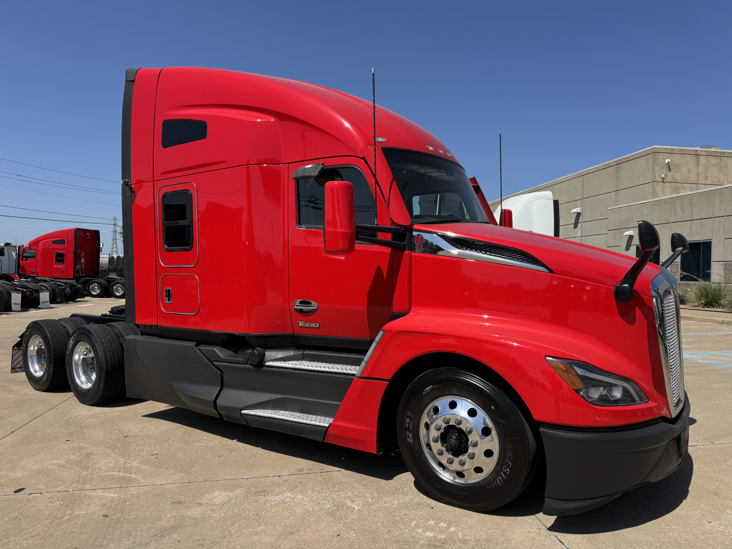 Kenworth T680 sleeper tractor in red, side view showing cab with aerodynamic mirrors, wheel rims, and fuel tanks. VIN 1XKYD49X7PJ230433, stock 0628335.