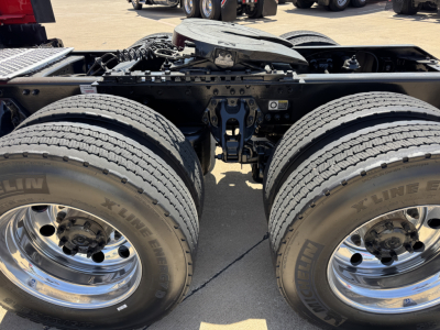 Kenworth T680 chassis showing dual rear axle wheels and suspension, with chrome wheels and X-Line tires, chassis frame and fifth wheel area visible.