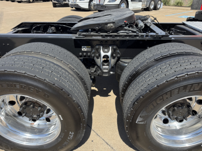 Kenworth T680 rear axle area showing dual rear wheels, chrome rims, and fifth wheel mount; visible fuel lines and chassis components in the center.