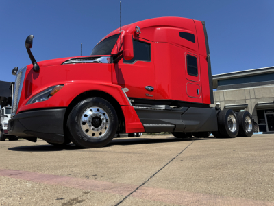 Kenworth T680 sleeper cab in red, side view showing front wheel, lower steps, and dual rear axles.