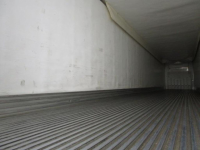 Inside View of refrigerated trailer interior showing ribbed floor and side wall with rear door; utility reefer with cargo area.
