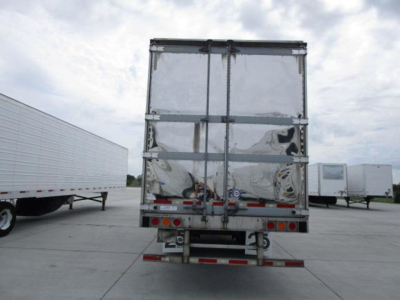 Refrigerated trailer rear view showing reflective aluminum doors and rear bumper with taillights; standard cargo seal bars across doors.