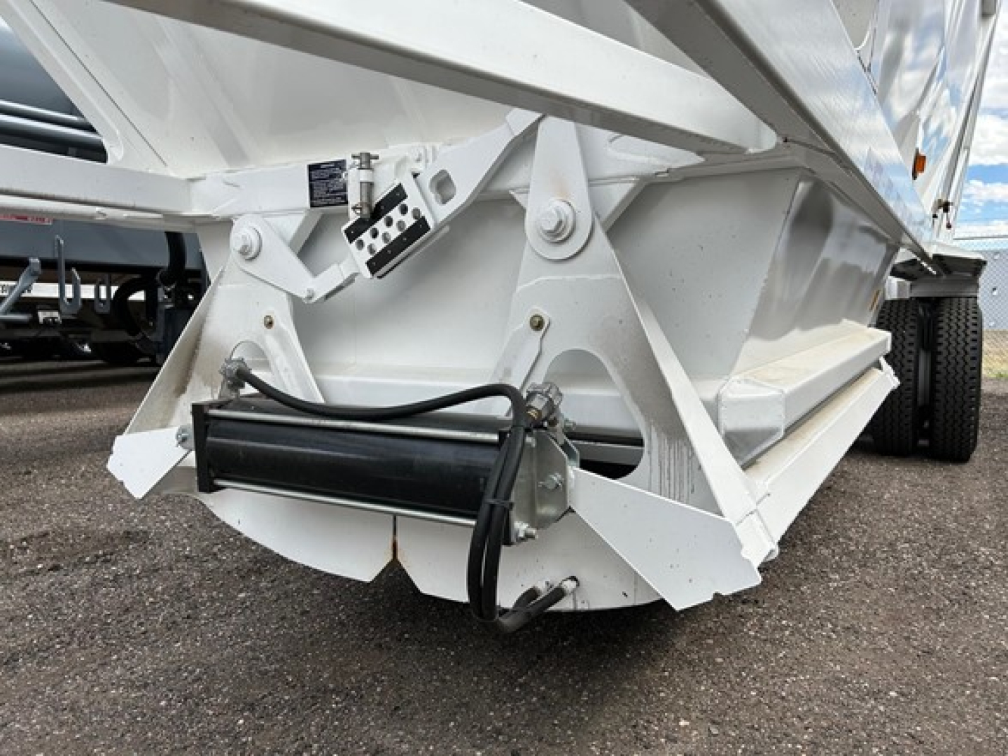 Trailer component with hydraulic cylinder and support frame showing undercarriage of a white dump trailer