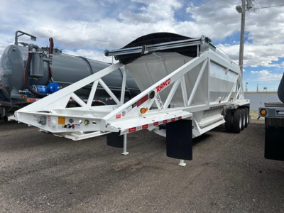 Ranco Versa dump trailer in an outdoor lot showing white structural frame and dual-axle configuration with RANGO branding and reflective markings.